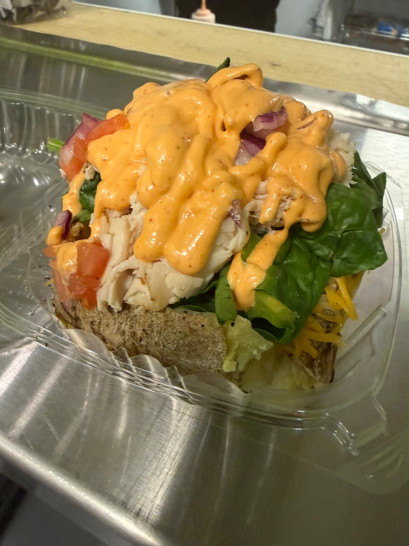 Eve's Garden Deli Silly Potato loaded with chicken spinach onions tomato and shredded cheese