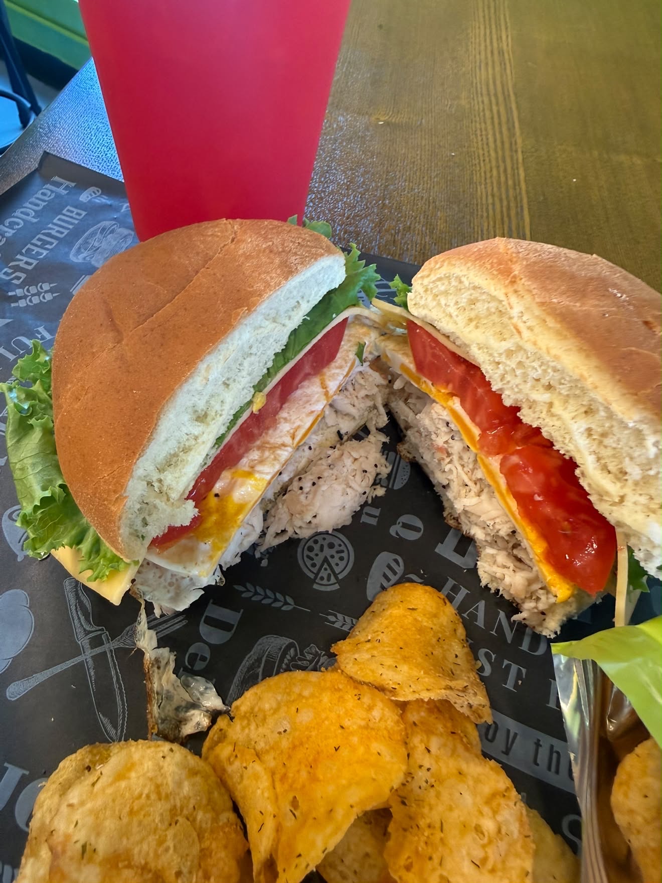 Eve's Garden Deli Mykail's Turkey sandwich with turkey egg lettuce tomato and gouda cheese on a Hawaiian bun served with kettle chips