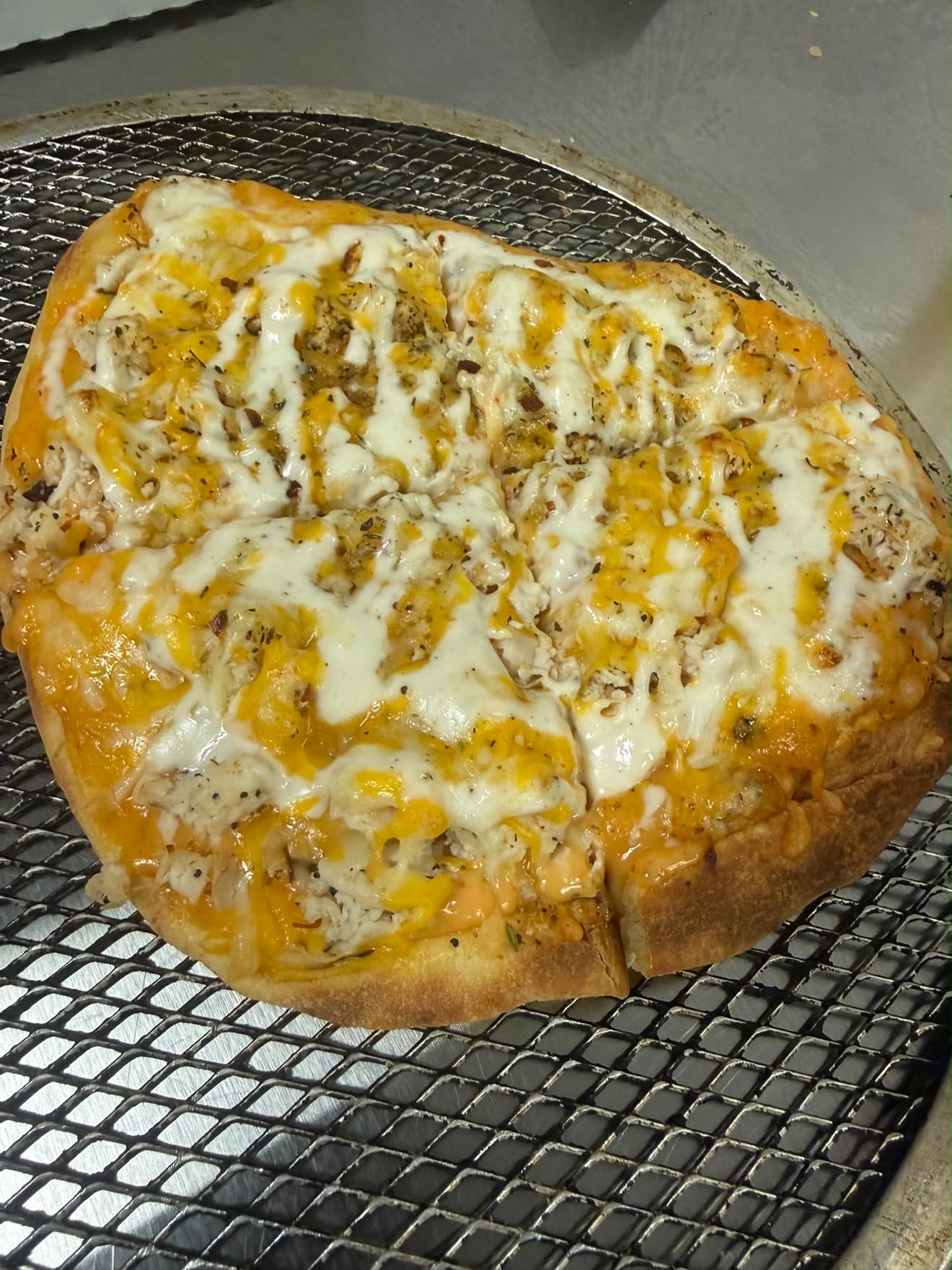 Eve's Garden Deli Buffalo Chicken Ranch Pizza with melted cheese fresh from the oven